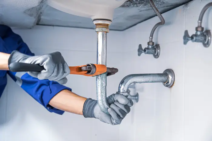 technician-plumber-using-wrench-repair-water-pipe-sink